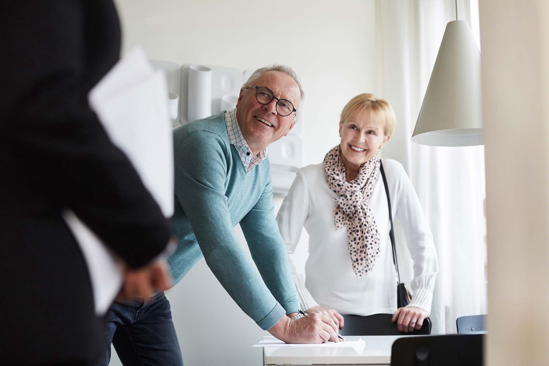 Man och kvinna som skriver på avtal för bostadsköp